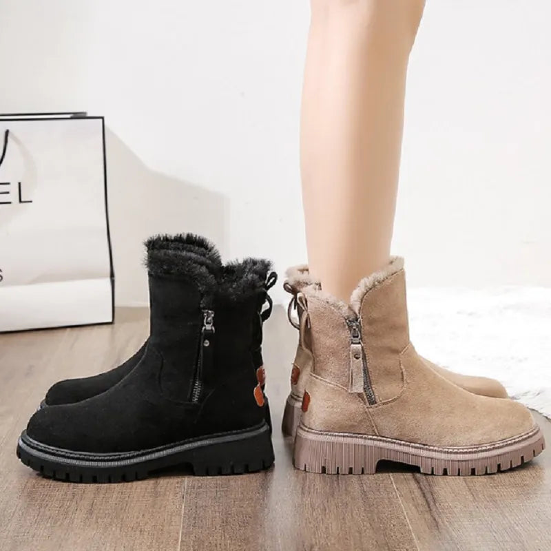 Bottes d'hiver en daim noir et beige avec doublure en fourrure, fermetures éclair latérales, semelles épaisses antidérapantes, sur plancher en bois.