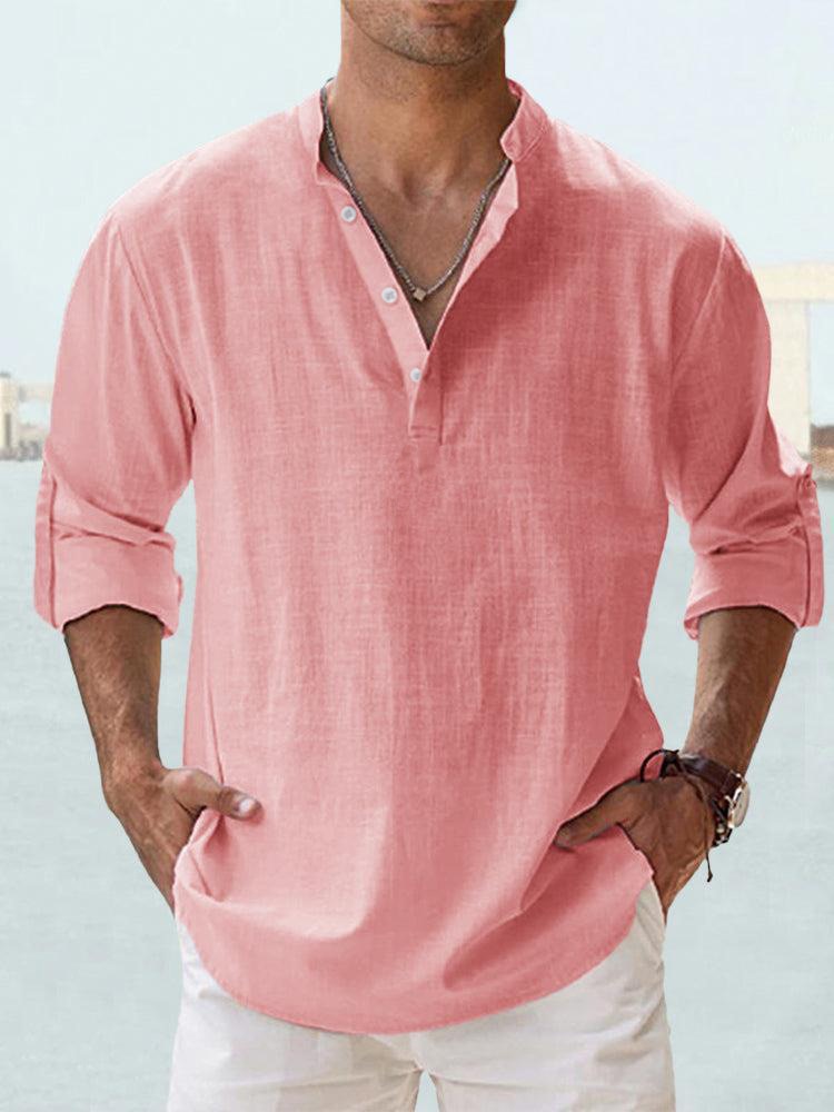 Homme portant une chemise en lin rose à manches longues retroussées, col boutonné, style décontracté, mode estivale masculine, fond flou.