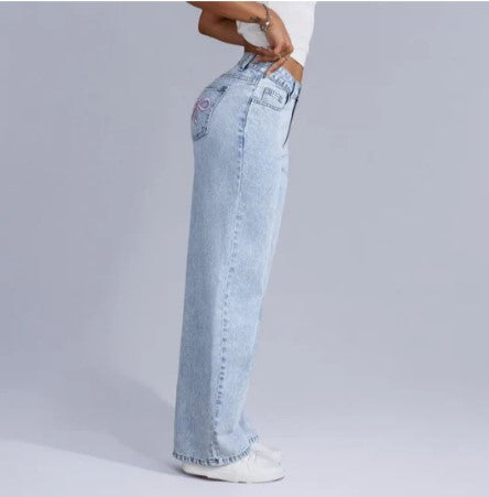 Jeans taille haute femme en denim bleu clair, coupe large, style décontracté, mode tendance, vue latérale, fond gris.