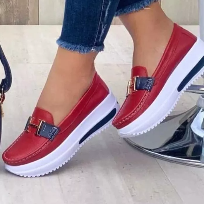 Chaussures mocassins rouges en cuir avec semelles compensées blanches, portées avec un jean. Mode féminine, tendance chaussures confortables.