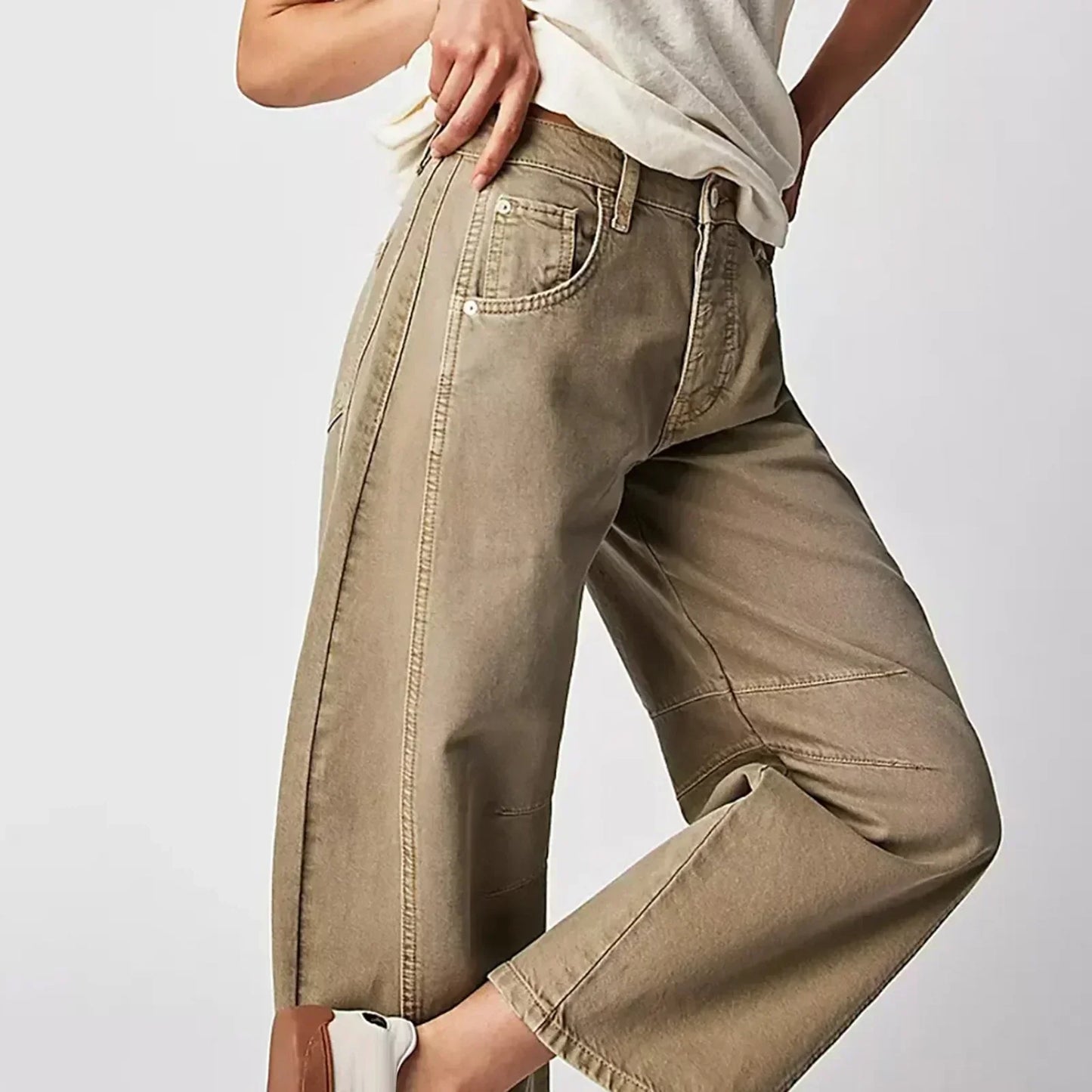 Pantalon large beige pour femme, taille haute, coupe ample, style décontracté, avec poches, porté avec un t-shirt blanc et baskets blanches.
