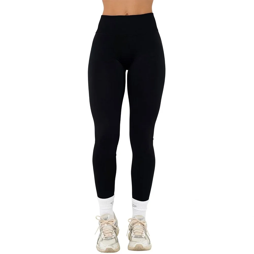 Sort træningstights til kvinder, høj talje, komfortabel pasform, ideel til fitness og yoga. Kombineret med hvide sneakers og sokker.