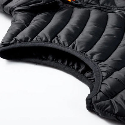 Gros plan d'une veste matelassée noire avec fermeture éclair, tissu imperméable et coutures renforcées. Mode hiver, vêtement chaud et isolant.