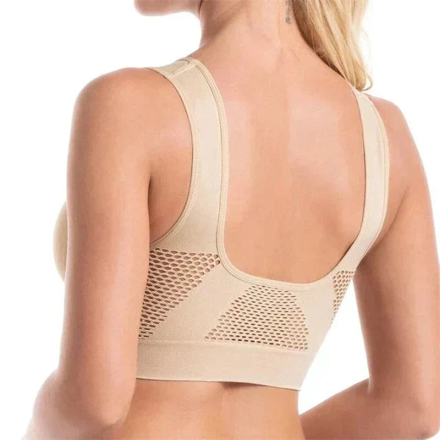Femme portant un soutien-gorge beige sans couture, dos en maille respirante, design confortable et élégant, lingerie féminine moderne.