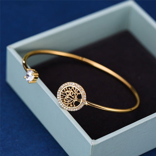 Goldenes Armband mit Lebensbaum-Anhänger und Kristall, eleganter Schmuck in Geschenkbox.