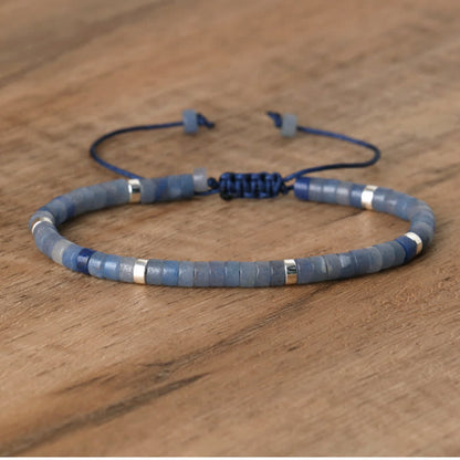 Blaues Armband aus Steinperlen mit silbernen Akzenten auf Holzoberfläche.