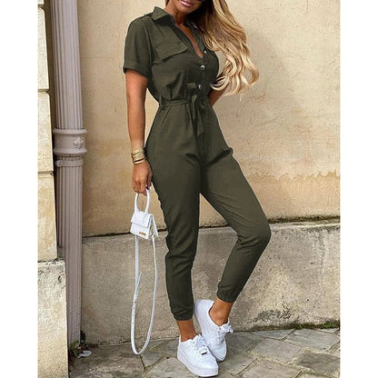 Combinaison verte élégante pour femme, manches courtes, ceinture à la taille, associée à des baskets blanches et un sac à main blanc tendance.