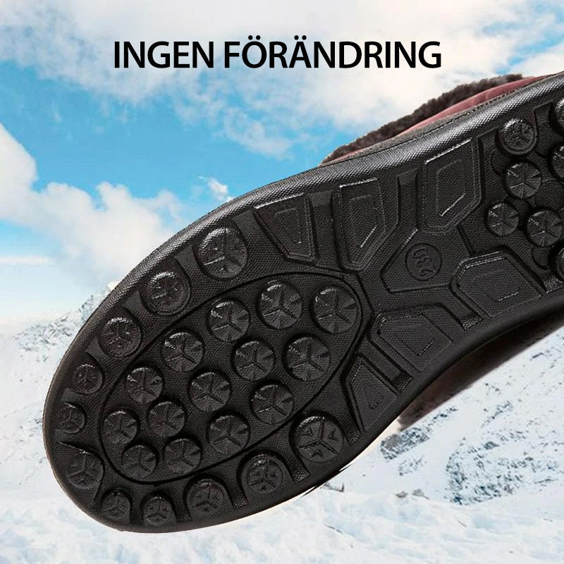 Semelle de chaussure antidérapante noire sur fond de neige et ciel bleu, idéale pour la randonnée hivernale. Texte en suédois en haut de l'image.