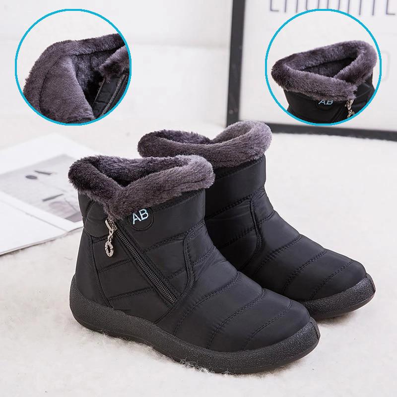 Bottes d'hiver noires pour enfants avec doublure en fourrure grise, fermeture éclair latérale et semelle antidérapante, posées sur un sol blanc.
