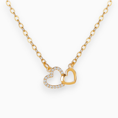 Goldene Halskette mit zwei Herzanhängern, einer mit Strasssteinen, eleganter Schmuck.