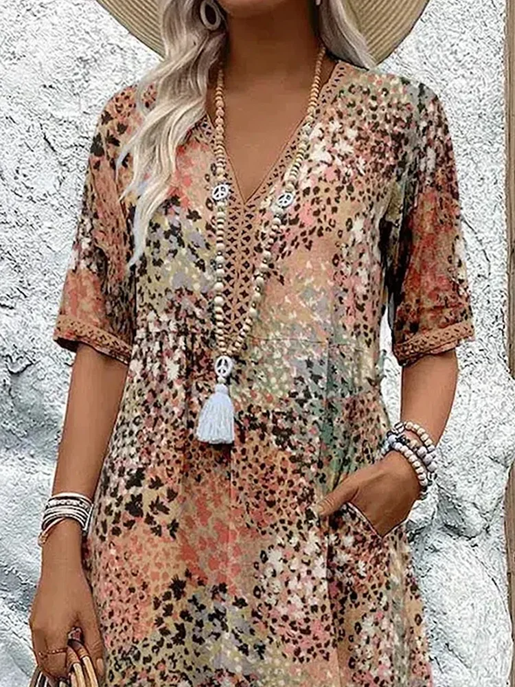 Robe d'été à motifs léopard multicolores, manches courtes, col en V, accessoirisée de colliers et bracelets, style bohème chic.