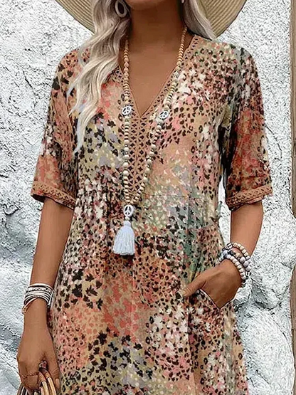 Robe d'été à motifs léopard multicolores, manches courtes, col en V, accessoirisée de colliers et bracelets, style bohème chic.