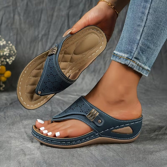 Blue sandals worn with jeans on a gray background