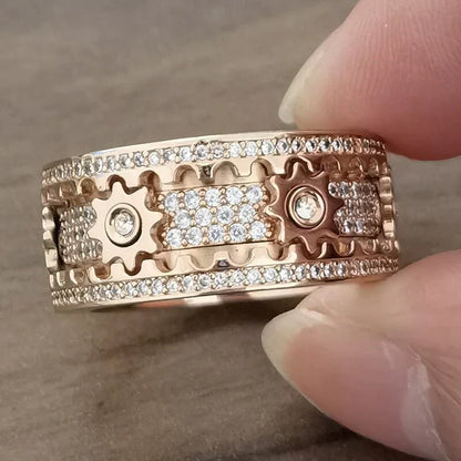 Roségoldener Ring mit Zahnraddesign und Diamantakzenten, luxuriöser Schmuck für Damen.