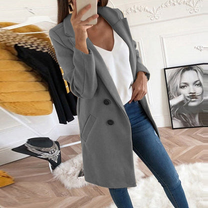 Frau im grauen Mantel, weiße Bluse, blaue Jeans, modernes Wohnzimmer, Selfie.
