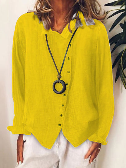Chemisier jaune vif en lin pour femme, manches longues, col en V, boutons noirs, porté avec un collier pendentif rond, style décontracté.