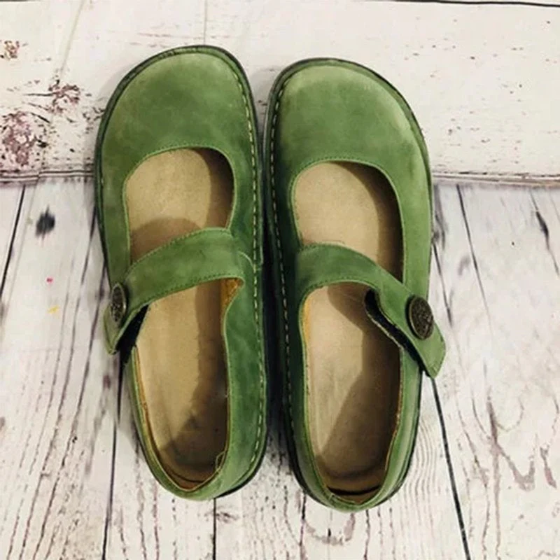 Chaussures vertes en cuir pour femmes avec bride, posées sur un sol en bois. Style décontracté, confort optimal, parfaites pour un look quotidien.