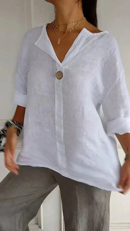 Blouse en lin blanc avec bouton en bois, manches retroussées, portée par une femme. Style décontracté, mode féminine, tenue estivale élégante.
