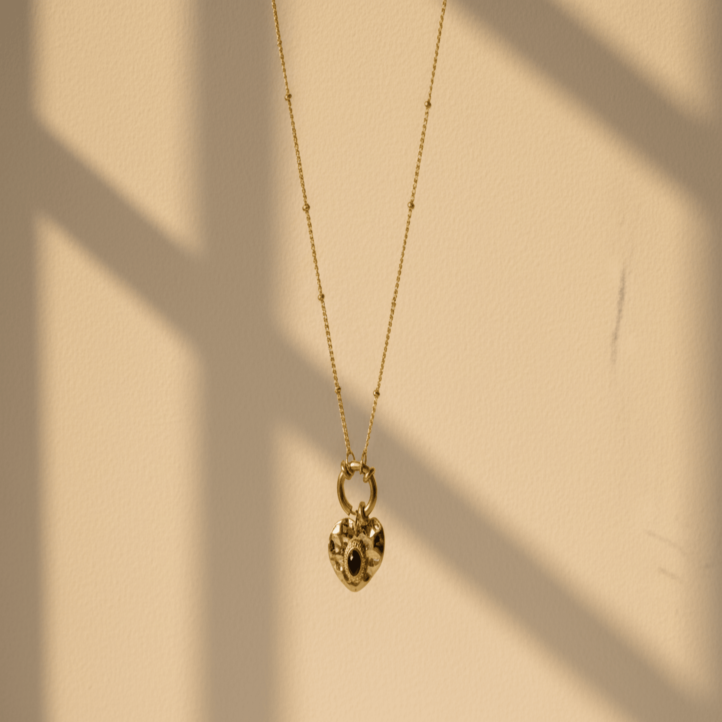 Monerose Soleil Ketting Zwart Hart variant, gouden hartvormige hanger met zwarte steen en schakelring, 18K goldplated 316L roestvrij staal, Lumière collectie van Monerose