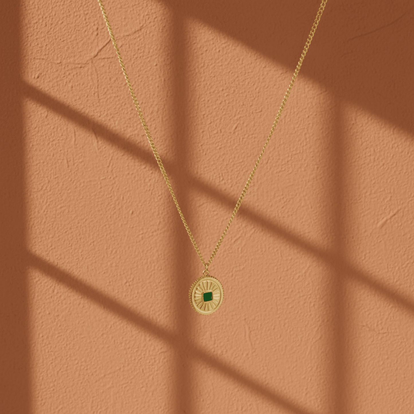 Monerose Soleil Ketting Smaragd Ovaal variant, gouden ovale hanger met smaragdgroene zirkoon steen en gegraveerde zonnestralen, 18K goldplated 316L roestvrij staal, Lumière collectie van Monerose
