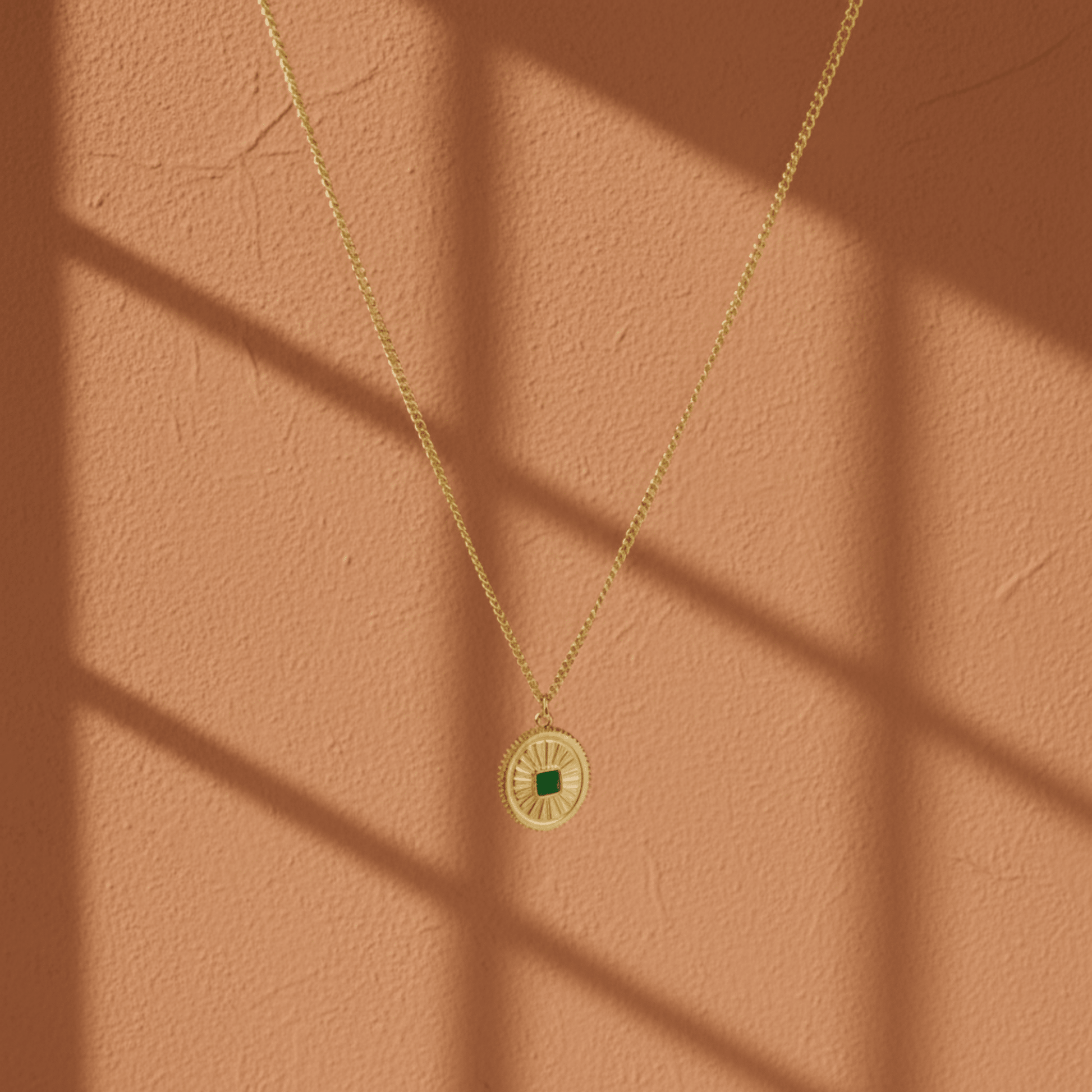 Monerose Soleil Ketting Smaragd Ovaal variant, gouden ovale hanger met smaragdgroene zirkoon steen en gegraveerde zonnestralen, 18K goldplated 316L roestvrij staal, Lumière collectie van Monerose