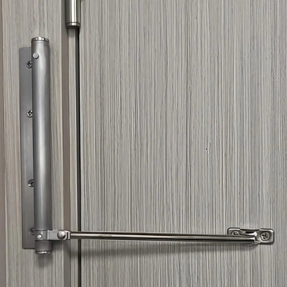 Silver finish automatic door closer mounted on light wood door in modern home interior setting