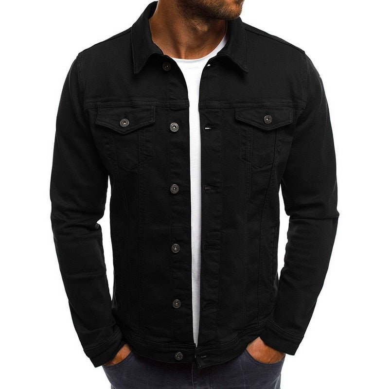 Veste en jean noire pour homme, style décontracté, manches longues, boutons classiques, poches poitrine, portée sur t-shirt blanc.