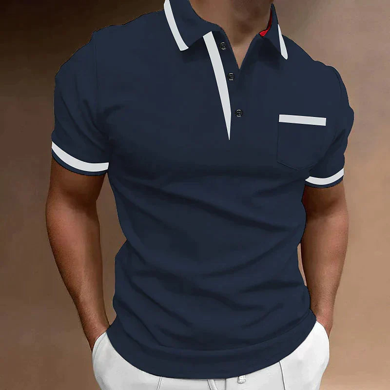 Homme portant un polo bleu marine élégant avec col blanc contrastant et poche poitrine, style décontracté chic, mode masculine tendance.