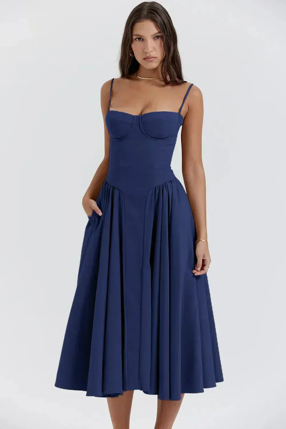 Robe bleue élégante avec bretelles fines, coupe ajustée et jupe évasée, portée par une femme. Mode féminine, tenue chic, style moderne.