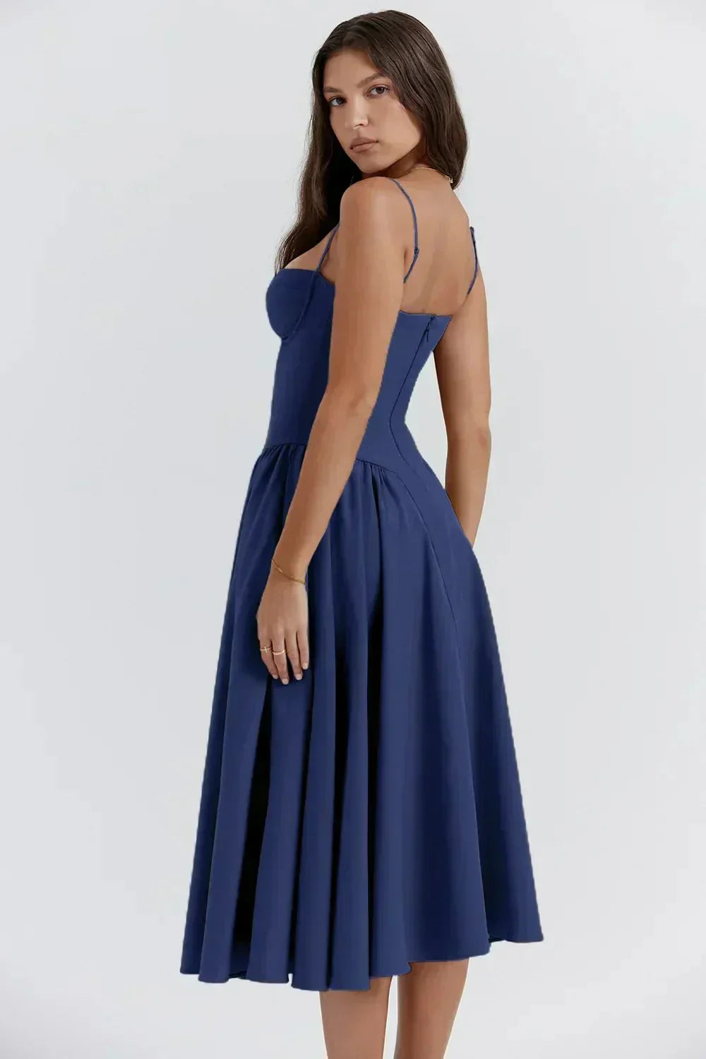 Robe bleue élégante portée par une femme, coupe évasée, bretelles fines, style chic et moderne, idéale pour soirées et événements formels.