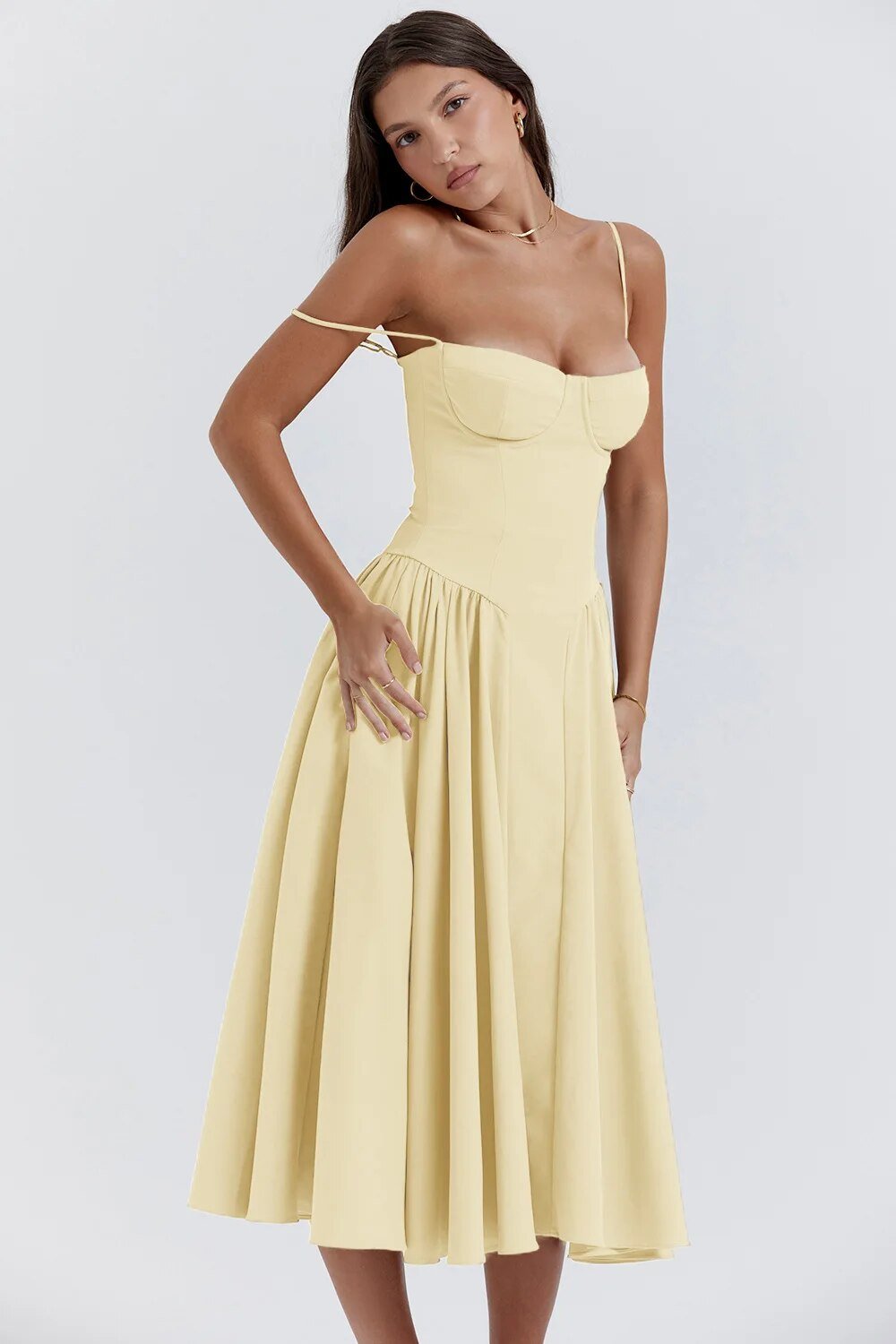 Robe midi jaune élégante, bretelles fines, corsage ajusté, jupe évasée, femme posant, mode féminine chic, tenue estivale tendance.