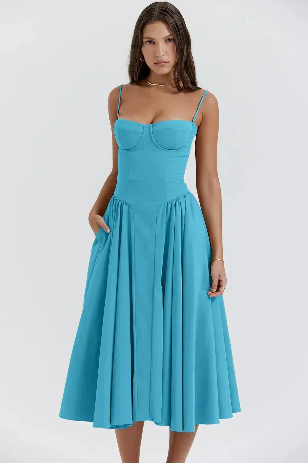 Robe bleue élégante à bretelles fines, coupe évasée, portée par une femme. Mode féminine, style chic, tenue estivale tendance.