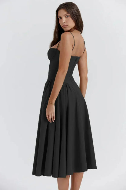 Femme portant une robe noire élégante, dos nu, longueur mi-mollet, bretelles fines, style chic et moderne, sur fond blanc. Mode féminine tendance.